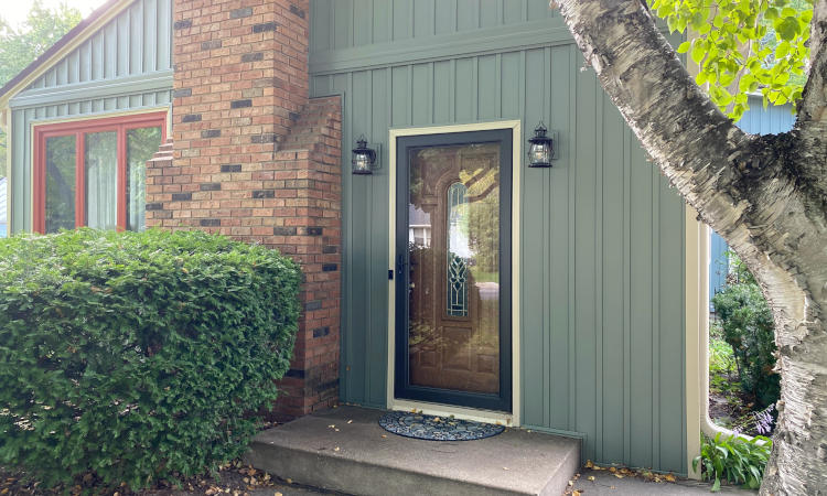 New wood front door with a black storm door.