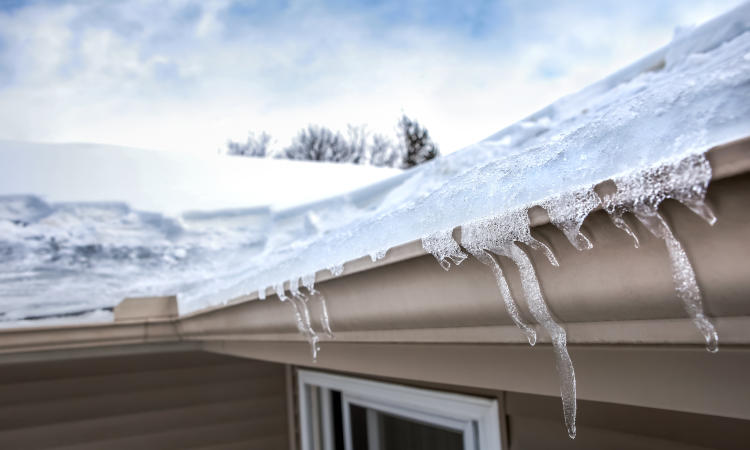 Ice dam in gutter and ice frozen on roof in winter