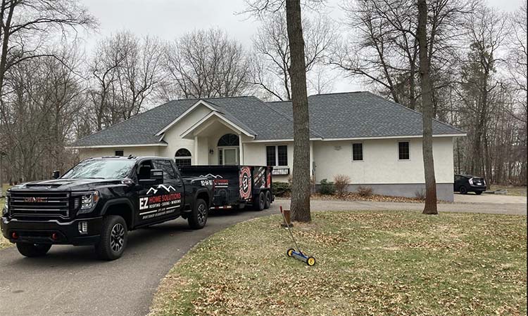 gray roof with company truck and dump trailer